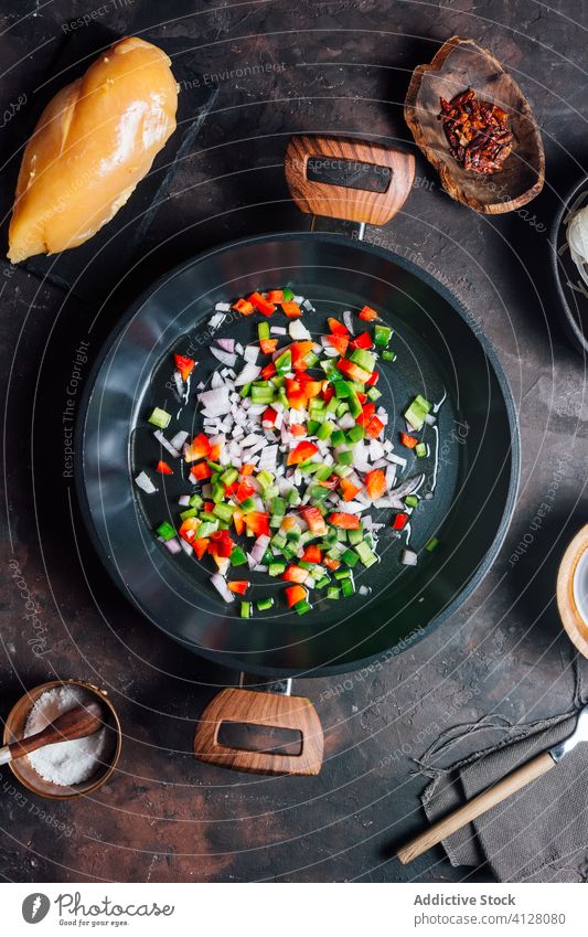 Top view of pan with mixing chopped pepper and onion for dinner food prepare ingredient noodle cook process chicken oriental dish cuisine tradition meal chef