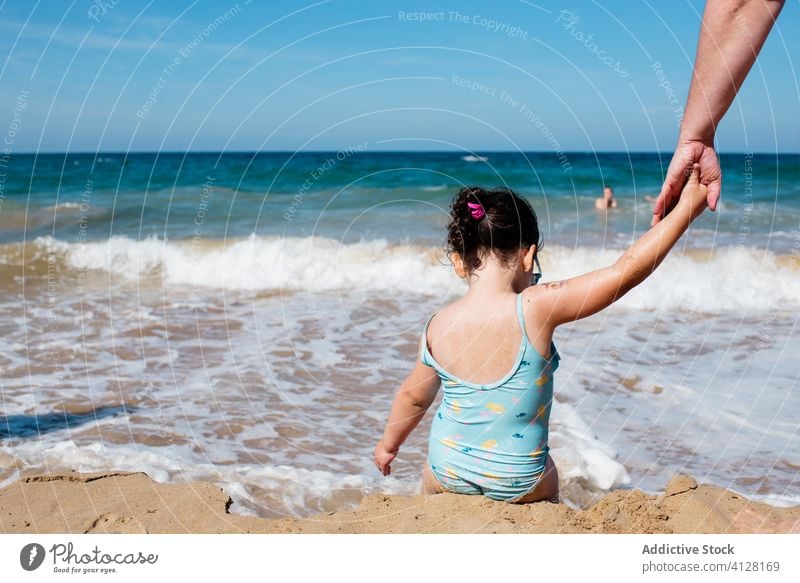 Little daughter and parent holding hands at seaside beach swimsuit girl little enjoy water seascape idyllic paradise coast shore seashore parenthood child