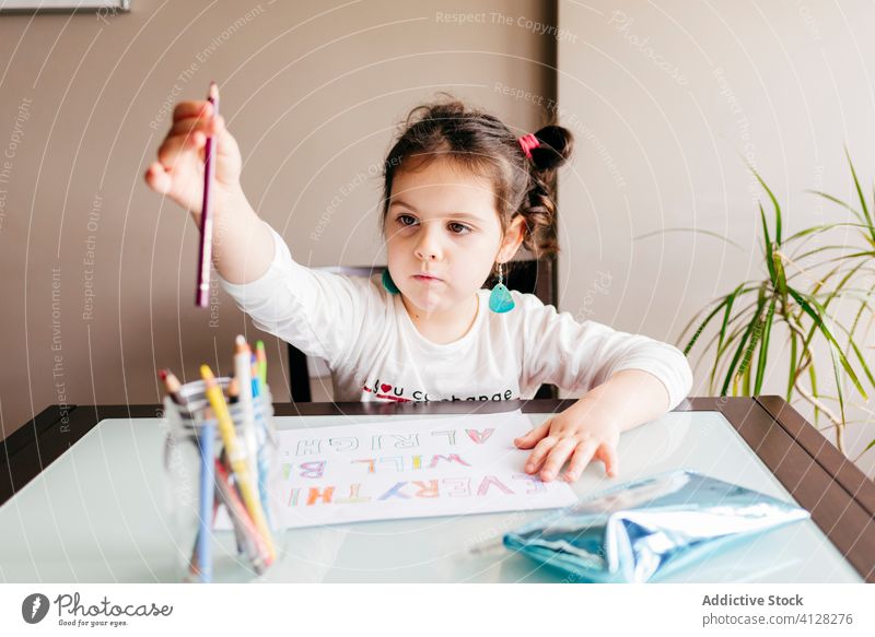 Serious little girl drawing with pencil on paper at home focus smart preschool learn upbringing develop child hobby kid table sketch paint colorful creative sit