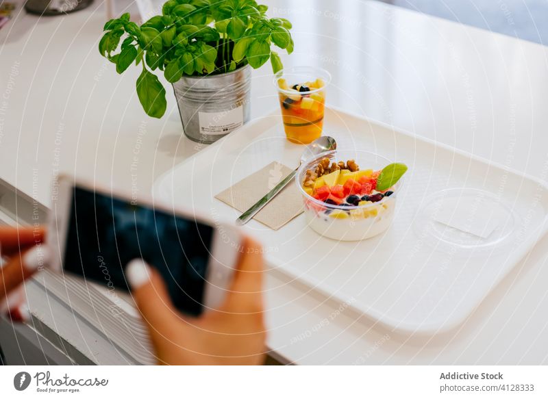 Anonymous woman taking photo of dessert on table with smartphone restaurant fruit take photo lunch food photography healthy fresh sit eat dish meal yummy gadget