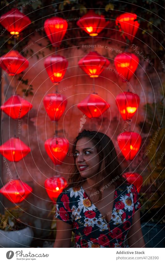 Smiling woman near Asian lanterns in evening illuminate street hang asian travel stroll smile female vietnam ethnic decoration tradition tourist admire chill