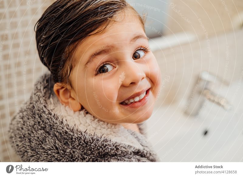 Adorable boy in bathrobe in bathroom wet hair kid sink cheerful soft little child wash basin cozy comfort cute home content delight positive glad happy hygiene