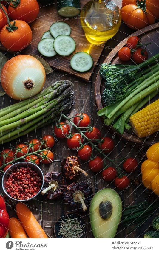 Variety of fresh healthy food consisting of tasty fresh vegetables berries and herbs on wooden rustic table harvest oil kitchenware layout background berry meal