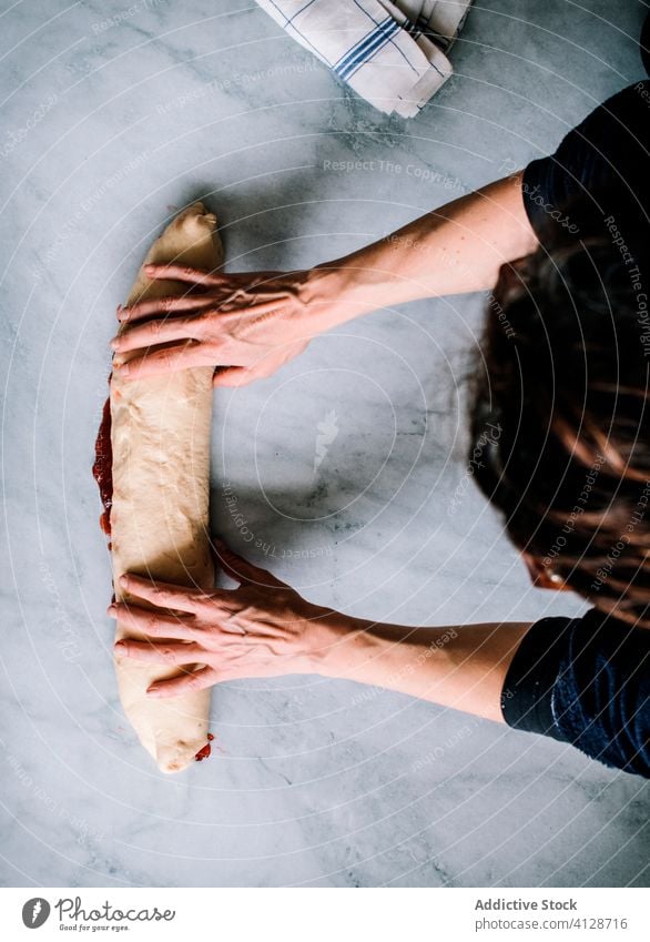 Anonymous person making fresh strawberry brioche on a marble table fruit preserve hands butter flour filling pastries sweet food sugar filled jam kitchen oven