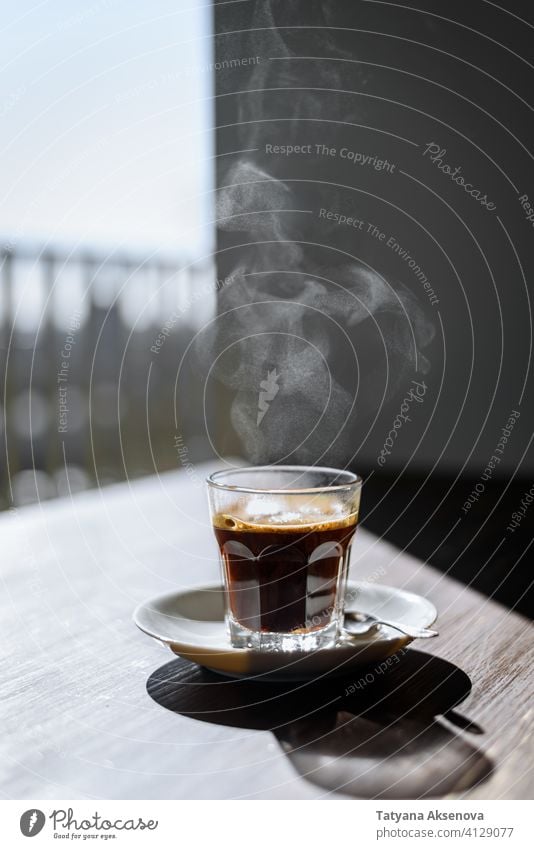 Glass of black coffee espresso hot cup drink morning breakfast steam table beverage cafe caffeine brown dark fresh scented refreshment taste hot drink