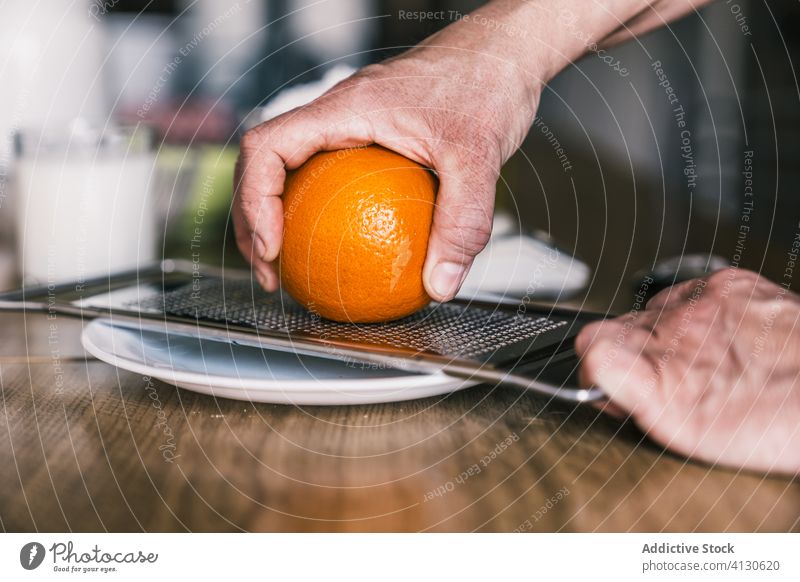 Housewife grating orange zest in kitchen grate ingredient prepare cook housewife pastry bake fresh aromatic homemade dough hand recipe food peel flavor sweet