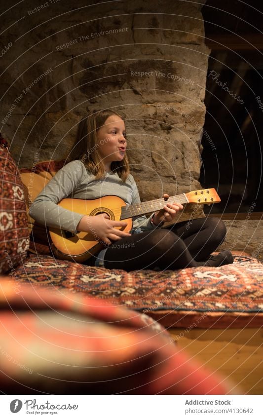 Girl playing ukulele on couch in stone house during vacation in Spain girl country practice sofa music comfort cozy cantabria spain relax leisure young enjoy