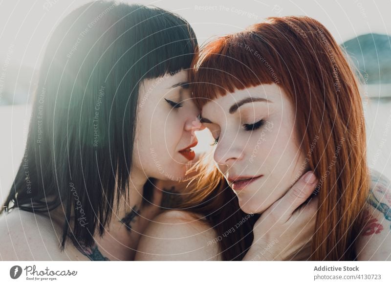 Tender lesbian couple in sunny winter field women love sensual snow touch allure lgbt tender together nature same sex embrace enjoy freedom passion kiss