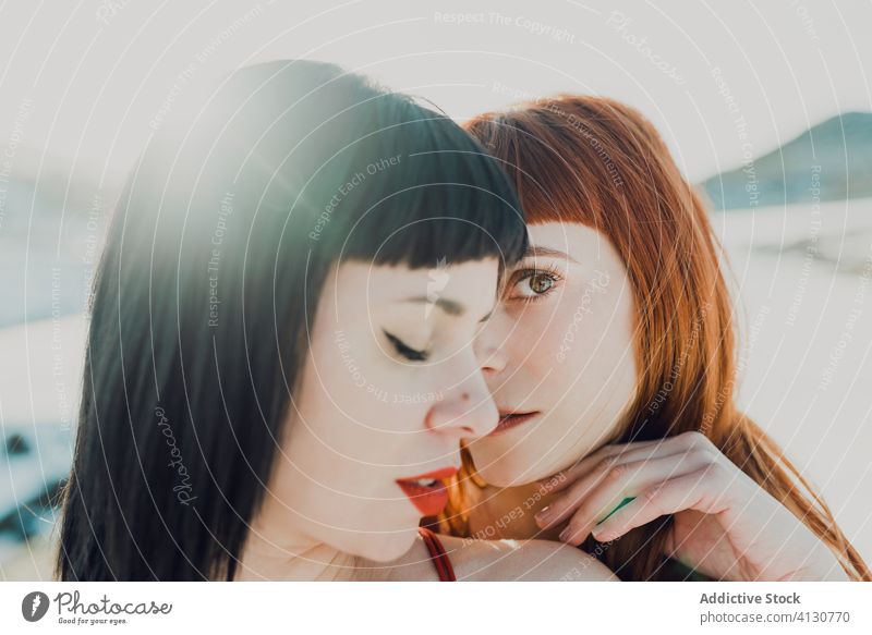 Couple of young women embracing in sunshine couple together embrace tender sensual charming girlfriend love affection relationship lesbian lgbt homosexual happy