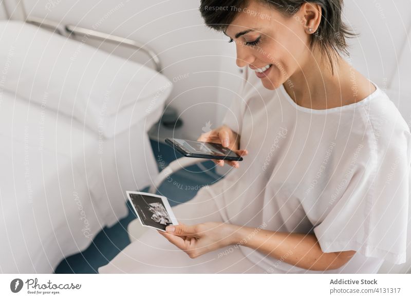 Happy pregnant woman taking photo of sonogram scan take photo pregnancy smile smartphone ward fertile patient female picture clinic hospital happy medicine