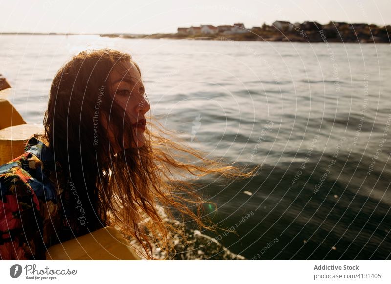 Young woman on embankment near sea breeze enjoy quay sunny seascape young casual female stand calm tranquil serene wind wavy hair relax chill vacation holiday