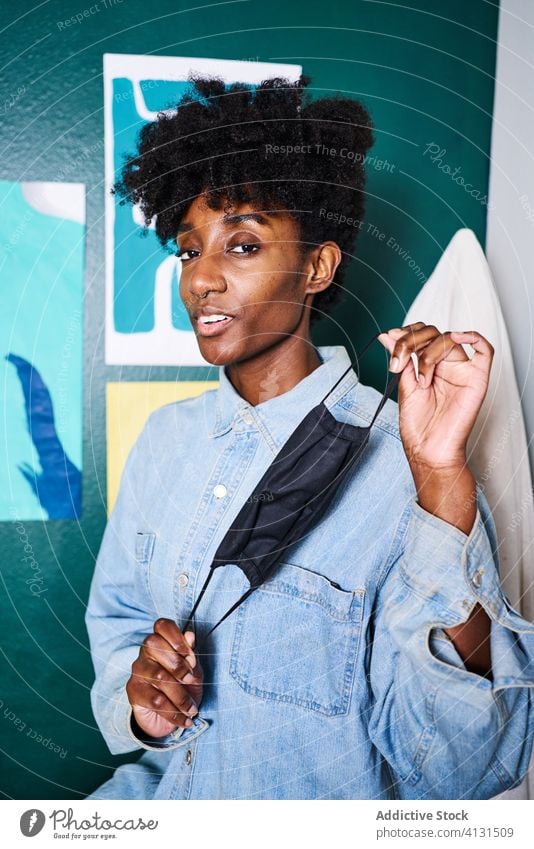 Young black woman with protective mask in hands stay home coronavirus covid show demonstrate positive young african american handmade ethnic female modern afro