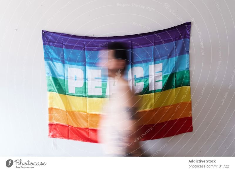 young Caucasian boy passing in front of a rainbow flag peace lgbt pride tattoo community right diversity equality proud human support colourful respect gay