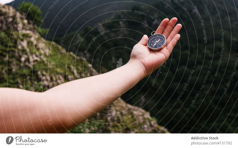 Crop traveler with metal compass hand tourist navigate orientate journey vacation direction location summer wanderlust explore destination adventure tourism