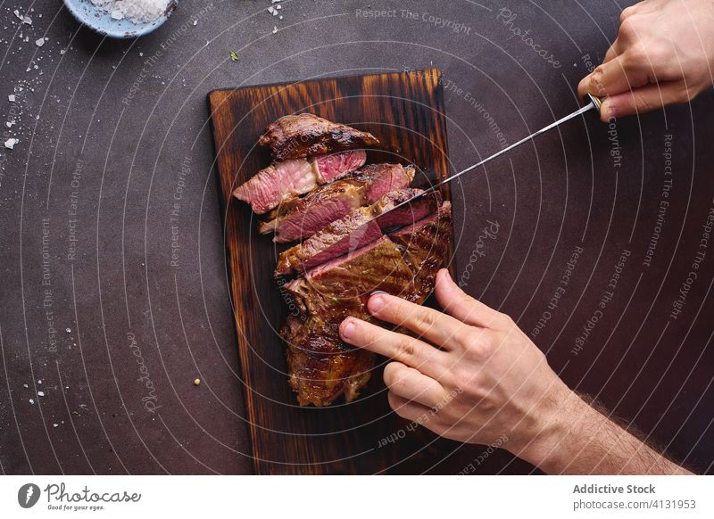 Hands cutting beef steak ribeye grilled black angus food meat cuisine hands beefsteak roasted tasty sliced closeup salt cooking filet protein fresh healthy