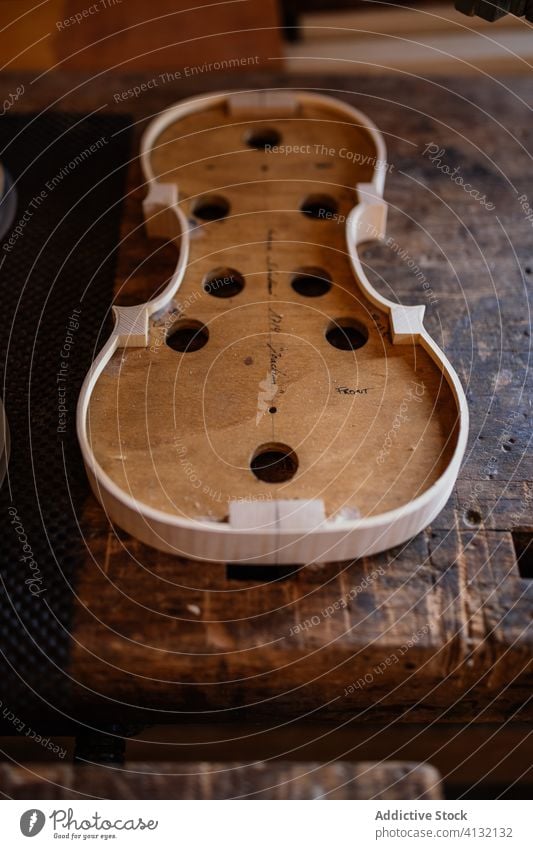 Soundboard of handmade violin on shabby wooden surface in workroom soundboard process workshop hole craft instrument workmanship create detail design