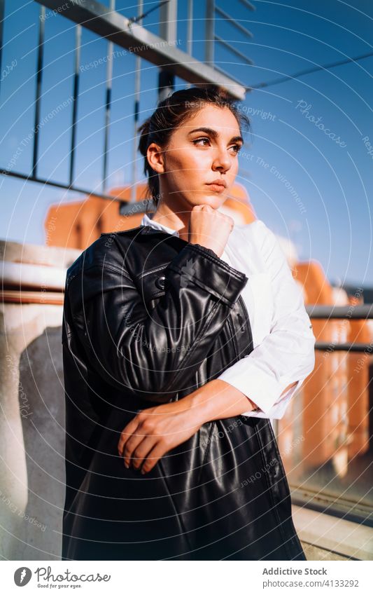 Calm stylish woman on balcony in summer trendy serene enjoy sun style leather jacket terrace female sunny relax rest tranquil calm harmony stand lady content