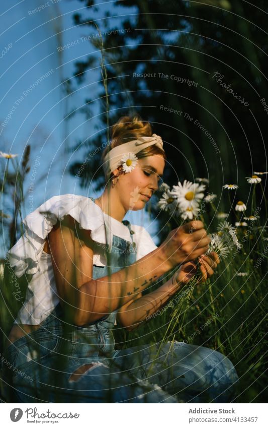 Calm female resting on green meadow in spring woman chamomile field rural pick collect smell calm enjoy bouquet fresh flower nature young bloom blossom relax