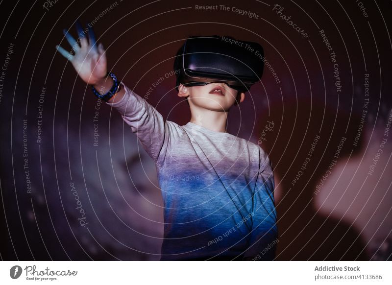 Bright projection on excited boy in VR headset vr colorful experience kid virtual reality explore technology simulation device gadget amazed face expression