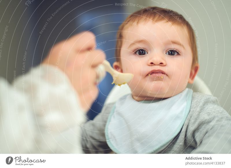 Mother feeding little kid with avocado baby eat mother food toddler fresh healthy natural meal child cute childhood hungry nutrition care tasty delicious diet