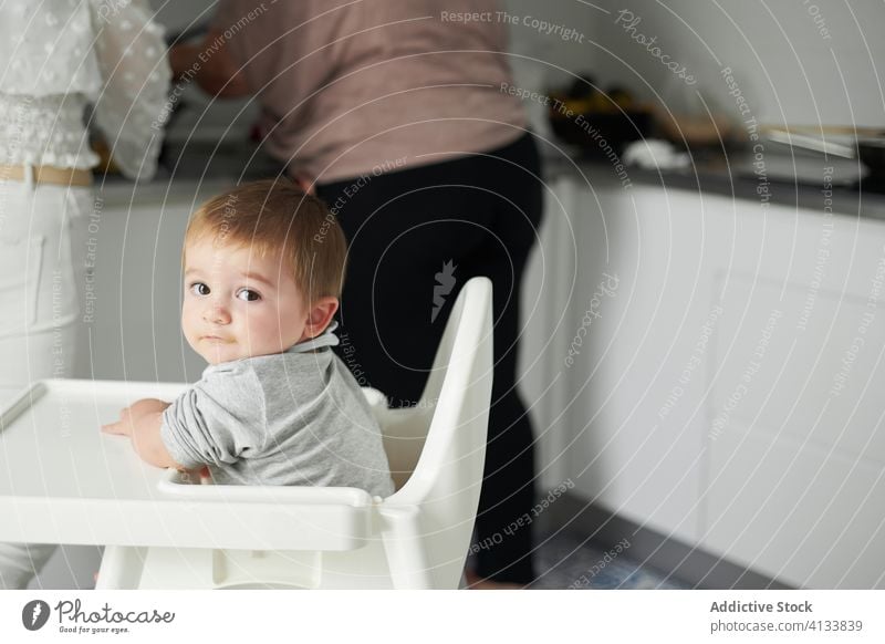 Cute baby waiting for food in kitchen chair home toddler child cute meal table kid childhood little eat prepare innocent calm hungry adorable seat domestic