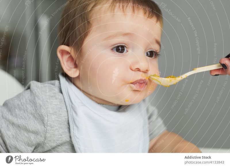 Mother feeding little kid with avocado baby eat mother food toddler fresh healthy natural meal child cute childhood hungry nutrition care tasty delicious diet