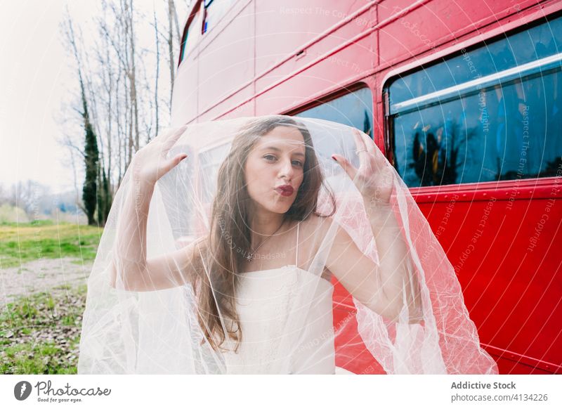 Amazed bride covering face with veil cover face newlywed amazed double decker wedding dress red bus surprise female elegant wood retro forest wedding day