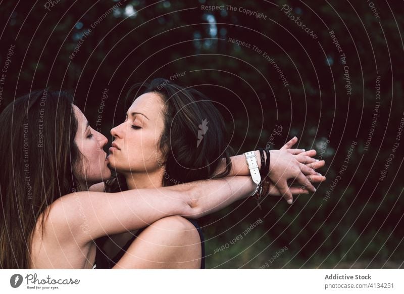 Young lesbian couple kissing on street women summer same sex summertime eyes closed daytime nature stroll walk young tender casual outfit homosexual lgbtq gay