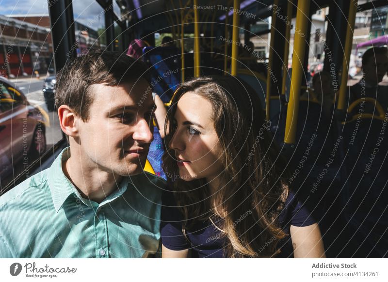 Couple in love holding hands in bus couple tender relationship public transport passenger together london england united kingdom seat sit touch close romantic