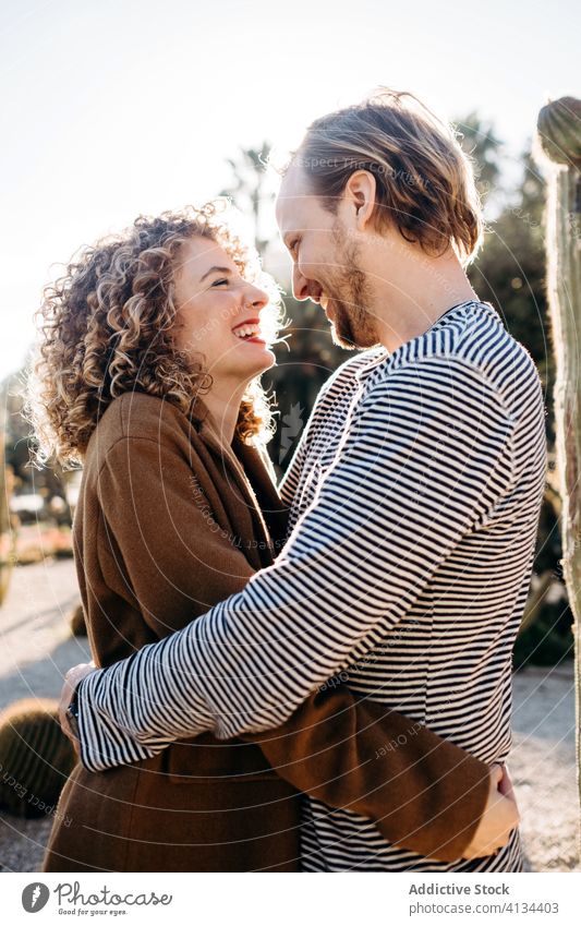 Happy couple hugging in cactus park love happy sunny daytime barcelona spain man woman excited relationship embrace cheerful summer together smile rest romantic