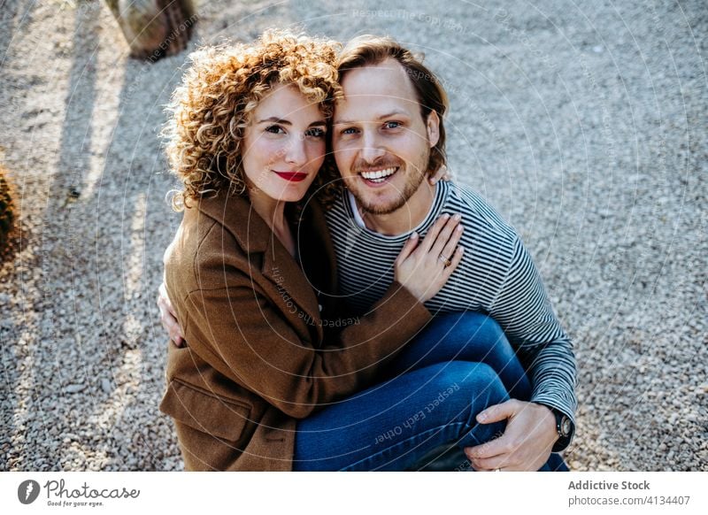 Happy couple hugging in cactus park love happy sunny daytime barcelona spain man woman excited relationship embrace cheerful summer together smile rest romantic