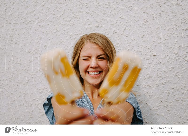 Happy woman with popsicles on white background grimace funny make face ice cream blink having fun lolly tasty smile female cheerful happy joy delicious stick