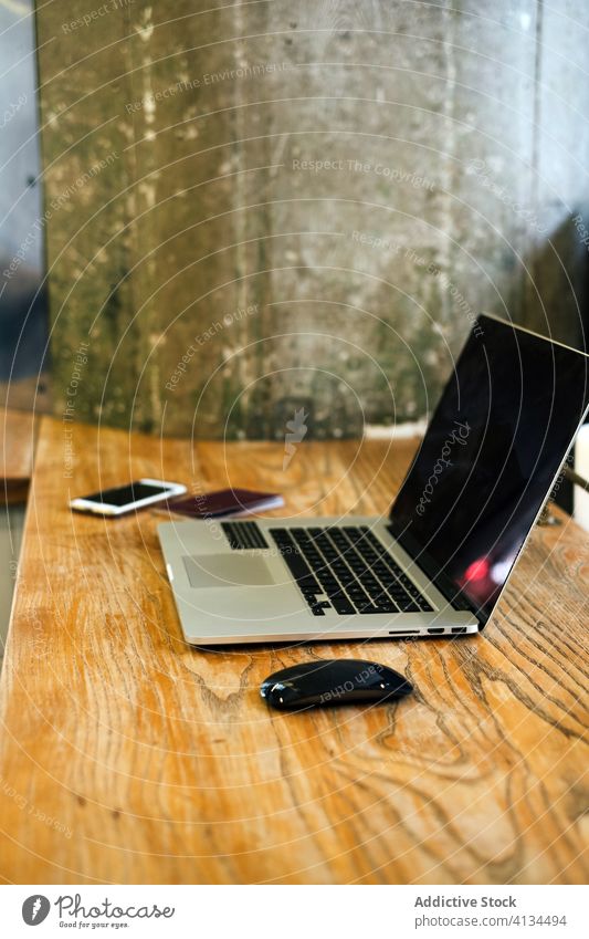 Laptop on wooden counter in cafe laptop netbook table modern cozy gadget coffee shop connection mouse device smartphone mobile internet freelance computer