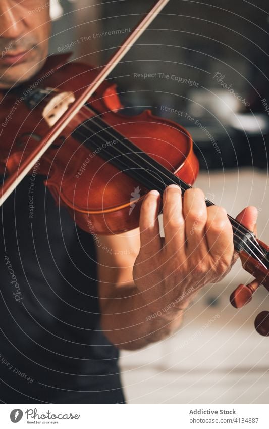 Anonymous male musician playing violin instrument man talent sheet violinist melody ethnic hispanic perform rehearsal sound entertain tune hobby rhythm player