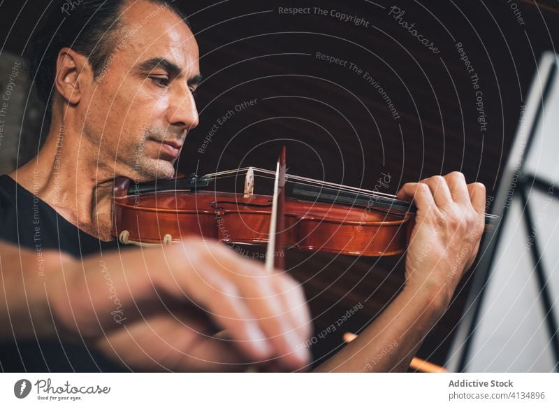 Ethnic male musician playing violin instrument man talent sheet violinist melody ethnic hispanic perform rehearsal sound entertain tune hobby rhythm player