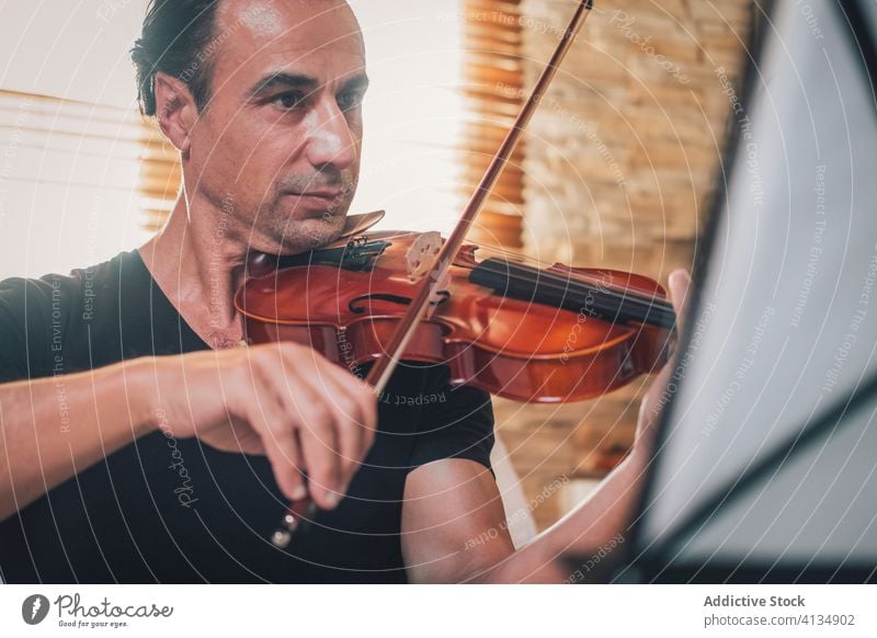 Ethnic male musician playing violin instrument man talent sheet violinist melody ethnic hispanic perform rehearsal sound entertain tune hobby rhythm player