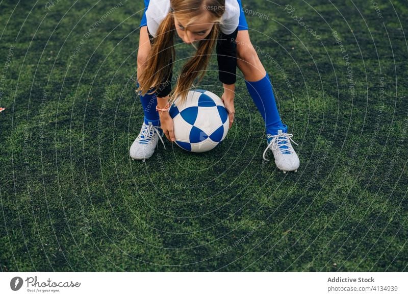 young female player playing football at sports stadium girl soccer field kid run uniform club training child game activity athlete equipment kick focus