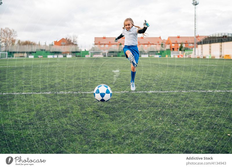 young female player playing football at sports stadium girl soccer field kid run uniform club training child game activity athlete equipment kick focus