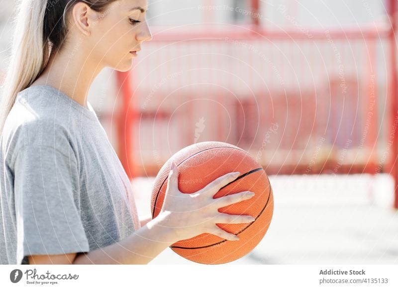 Confident basketball player standing on playground woman confident sport court competitive serious young sportswoman athlete sportswear training activity game