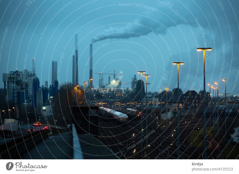 Industrial landscape with freight trains, industrial plants and blue hour lighting. Industry, logistics, rail traffic Industrial district Freight trains