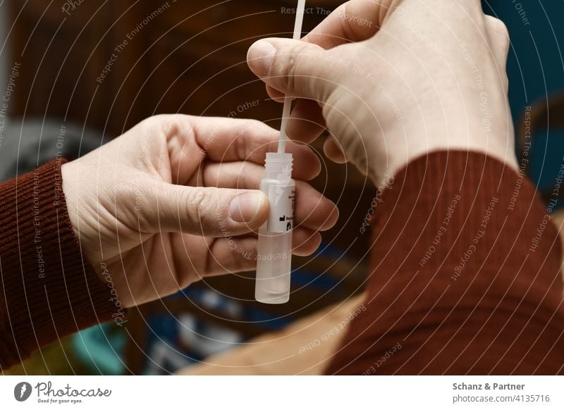 Hands insert test sticks into test liquid of a Covid 19 test Quick test corona Test sticks self-test covid-19 Test fluid lockdown Test strategy home office