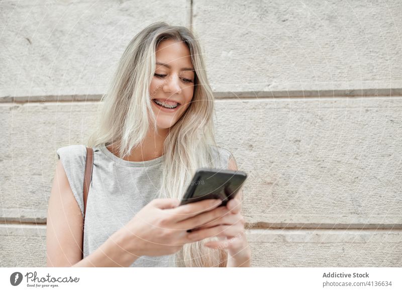 Woman with smartphone standing on street woman city using young happy style message browsing female mobile phone lifestyle device gadget urban smile trendy