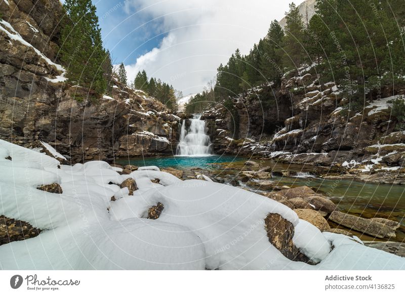 Waterfall with pool among snowy mountains waterfall forest nature landscape winter wild stream picturesque scenic environment rock scenery harmony cold season