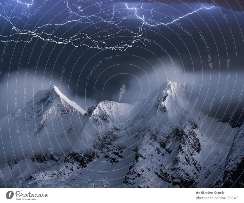 Lightning over rocky mountain peak lightning storm rough snow cliff dramatic dark sky landscape murk night nature stone evening environment scenery majestic