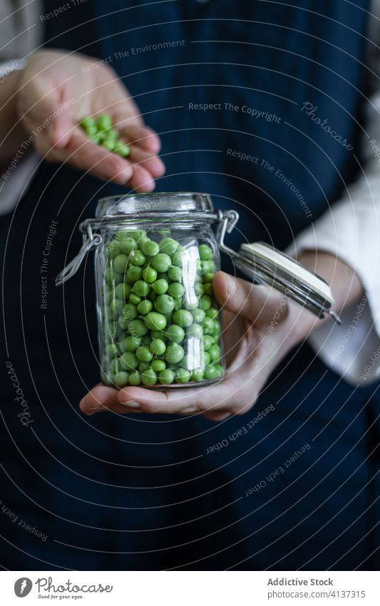 Crop cook with jar of peas green vegetable fresh person glass can organic natural apron food healthy nutrition delicious diet tasty plant meal gourmet vegan