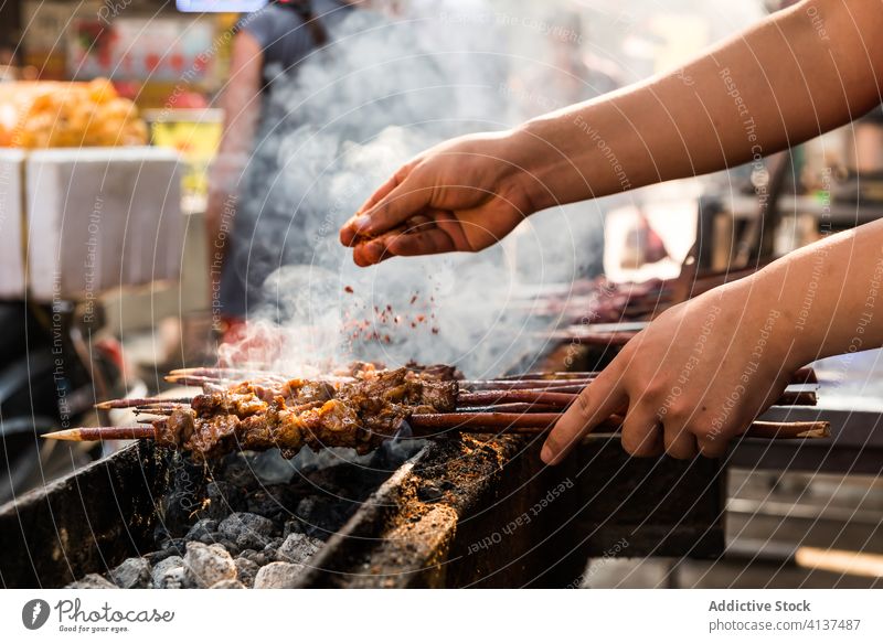 Crop male cook preparing kebab on grill man skewer prepare process seasoning add meat delicious food meal dish tasty cuisine dinner barbecue roast gourmet fresh