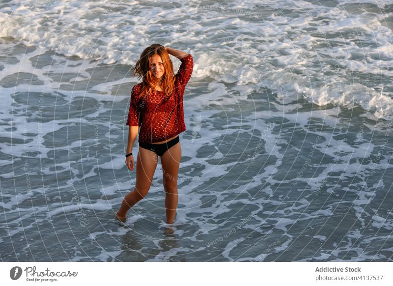 Cheerful traveling woman on beach during summer vacation sea bikini enjoy seaside wave holiday female glad cheerful tourist water relax sun rest trip seashore