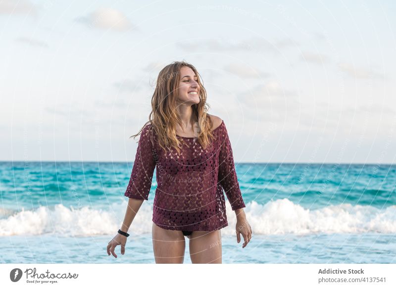 Cheerful traveling woman on beach during summer vacation sea bikini enjoy seaside wave holiday female glad cheerful tourist water sun rest trip seashore foam