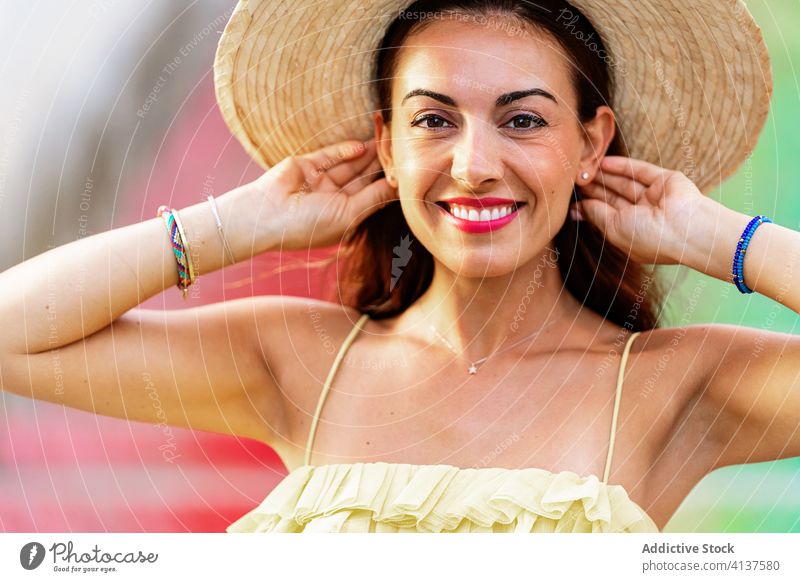 Carefree traveling woman on colorful stairs tourist carefree enjoy holiday city summer rainbow female sunny step charming dress vacation straw hat smile freedom