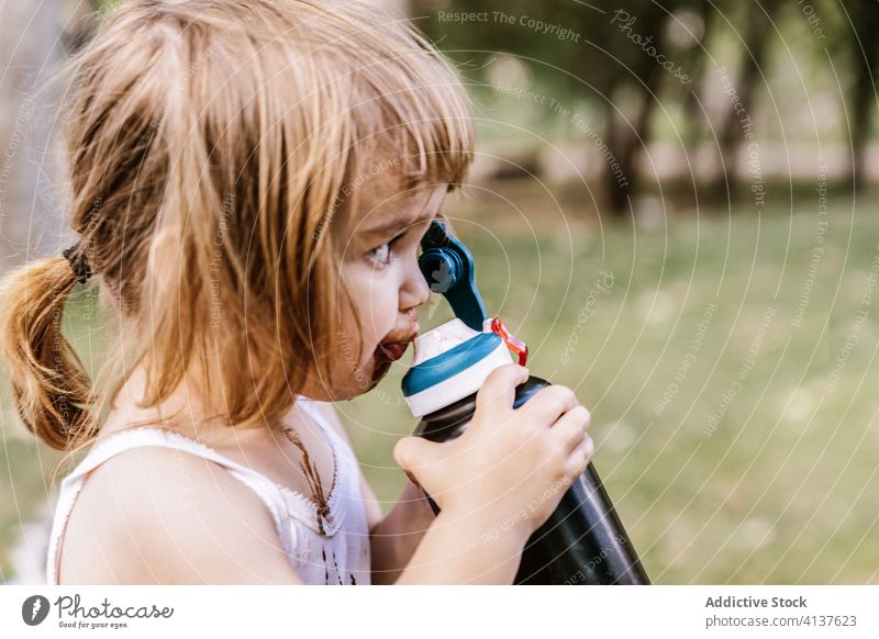 Little girl drinking water in park child kid fresh little bottle summer cute adorable dirty plastic liquid refreshment beverage healthy childhood thirst rest